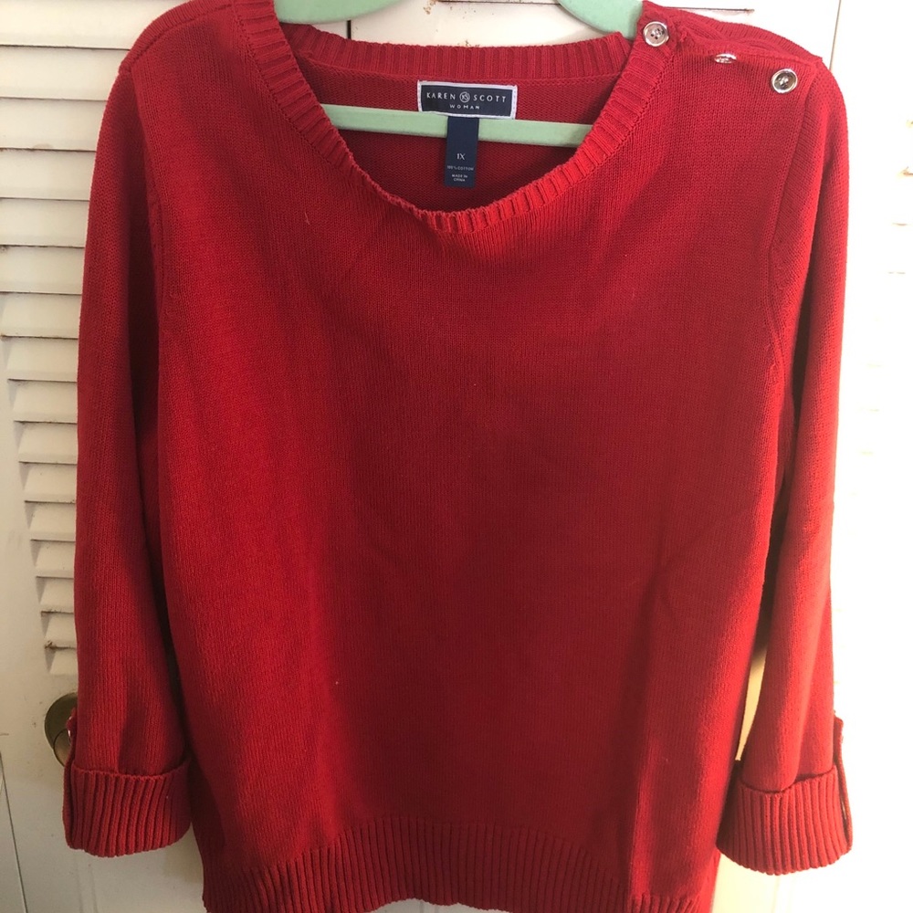 Red Karen Scott sweater with button accent.